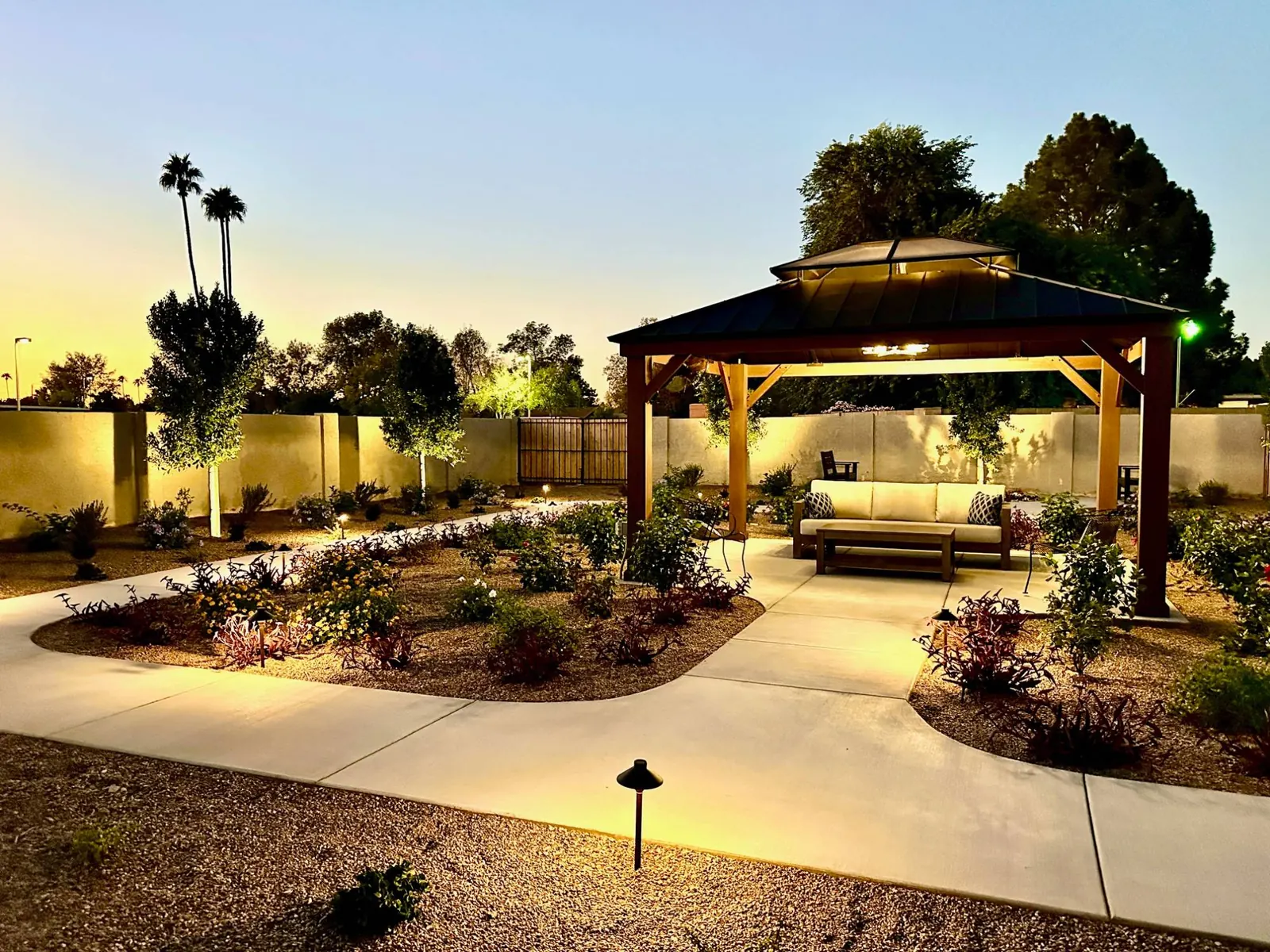 The lit gazebo and garden paths at dusk